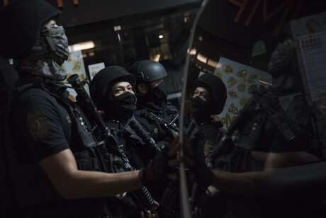 Drei schwarz gekleidete und schwer bewaffnete Sicherheitskräfte stehen nebeneinander