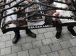 Demonstrierende halten ein Schild, auf dem das abgebrannte Haus von Milan Jovanovic zu sehen ist. Unten auf dem Schild ist der Schriftzug "Auf was warten wir?" zu lesen. © picture alliance/AP Photo | Darko Vojinovic