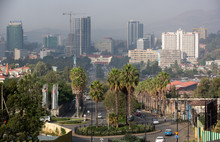 Hinter einem von Bäumen umgebenen Kreisverkehr ist die Skyline von Addis Abeba zu sehen